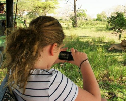 Al igual que esta joven, tendrás la oportunidad de fotografiar diferentes animales durante tu safari económico de 4 días en Tanzania.