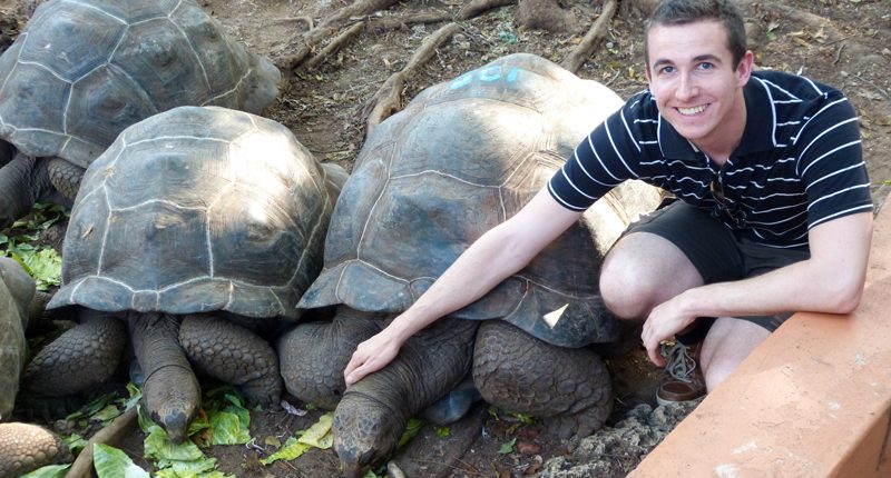 Uno de nuestros invitados posa con una tortuga gigante en la Isla de la Prisión